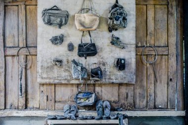 Kırsal duvarda asılı eski kullanılmış yürüyüş ekipmanlarının yakın çekim görüntüleri.