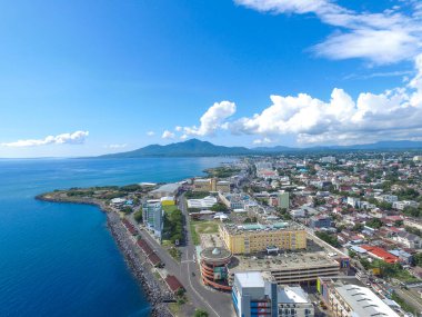 Manado, 20 Haziran 2020: güneşli bir günde Manado Endonezya 'nın mavi suları ve sahil otelleri ile gökdelenler marinası