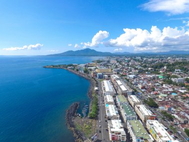 Manado, 20 Haziran 2020: güneşli bir günde Manado Endonezya 'nın mavi suları ve sahil otelleri ile gökdelenler marinası
