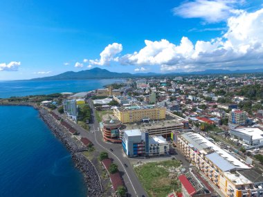 Manado, 20 Haziran 2020: güneşli bir günde Manado Endonezya 'nın mavi suları ve sahil otelleri ile gökdelenler marinası