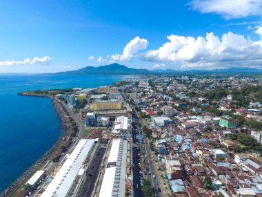 Manado, 20 Haziran 2020: güneşli bir günde Manado Endonezya 'nın mavi suları ve sahil otelleri ile gökdelenler marinası