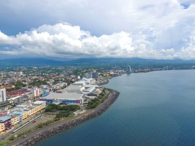 Manado, 20 Haziran 2020: güneşli bir günde Manado Endonezya 'nın mavi suları ve sahil otelleri ile gökdelenler marinası