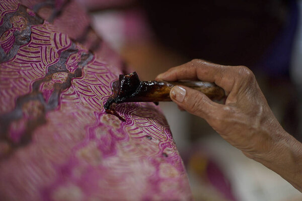 Surakarta, Indonesia - August, 7, 2020 : Canting batik background on the fabric. Drawing Batik Tulis