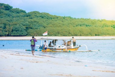 Endonezya 21 Haziran 2020: Beyaz kumlu plajlı tropikal ada ve mavi şeffaf su ve mercan resifleri. Hava saldırısı, sürat tekneleri, uzun kuyruklu botlar, Gili Trawangan Adası Endonezya
