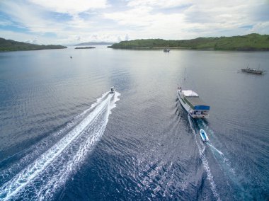 Mavi sulardaki gemilerin tropikal adalarla çevrili hava manzarası
