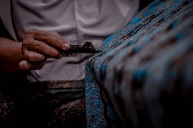 Endonezya 18 Haziran 2020: Batik, Close Up hand and canting, make Batik Tulis Endonezya. Canting kumaşın dokusunu çizmek için bir araçtır.