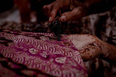 Endonezya 18 Haziran 2020: Batik, Close Up hand and canting, make Batik Tulis Endonezya. Canting kumaşın dokusunu çizmek için bir araçtır.