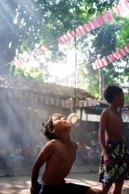 Endonezya 17 Ağustos 2020: Asyalı bir çocuğun Makan Kerupuk ile sahada eğlenirken portresi. Endonezya bağımsızlık günü konsepti