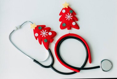 Stetoskop kırmızı Noel boynuzlarıyla süslenmiş. Doktorları tebrik etmek için arka plan. İlaç ve hayat. Noel tatili.