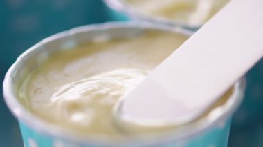 Yakın çekim şefleri mavi bir cupcake üzerinde bir spatula yayılan krem peynir kullanıyor, cu shot