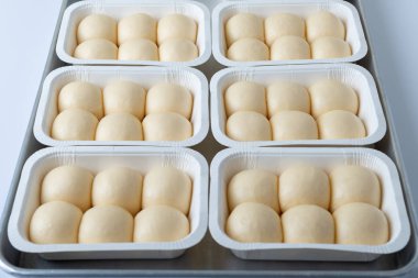 Hamur ekmek fırında beyaz kağıt tepsisi üzerinde.