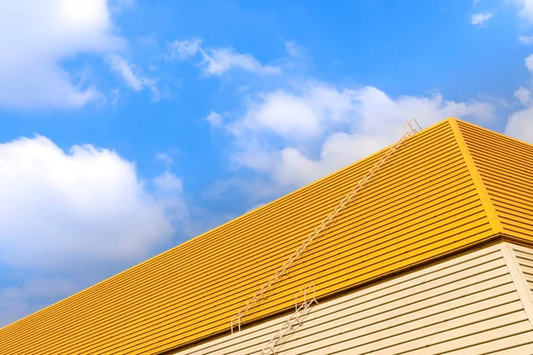 蓝色天空的黄色背景上的屋顶. — 图库照片