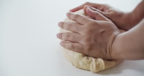 Cerca de las mujeres amasando la masa con las manos en una mesa blanca, cámara lenta, 4K — Vídeos de Stock