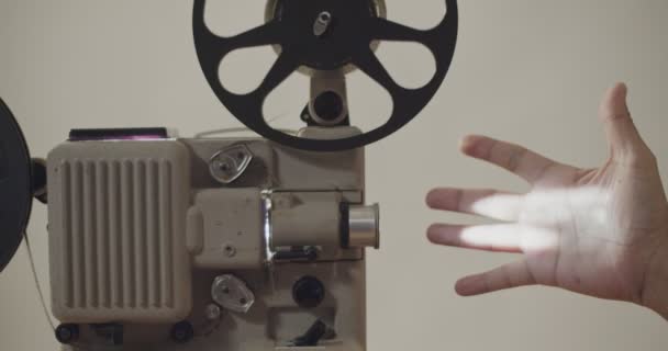 Les mains agitaient le projecteur de lumière 8 mm film rétro lecture . — Video