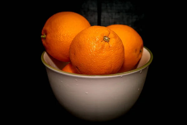 橘子在碗中的黑色背景 — 图库照片