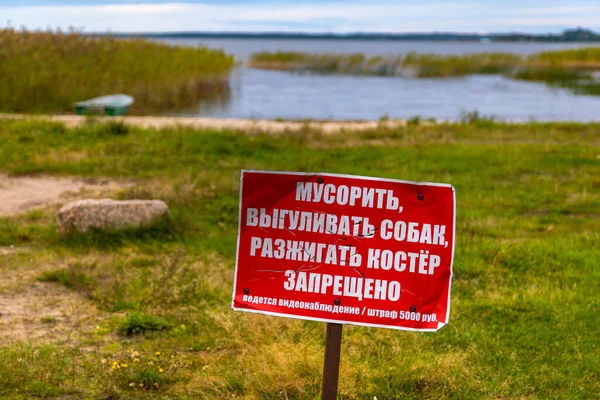 Gölün arka planında kırmızı uyarı işareti var. Çevirisi: Çöp atmak, köpekleri gezdirmek, ateş yakmak yasaktır..