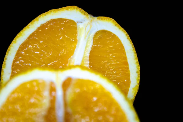 两个多汁的橙子在黑色的背景上切成两半 — 图库照片