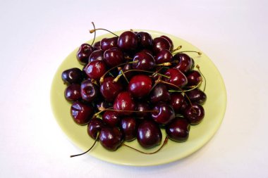 Açık yeşil yuvarlak plaka olgun koyu kırmızı kiraz