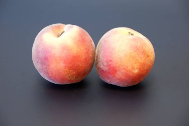 Koyu gri arka planda iki taze sulu şeftali görünümü kapatın