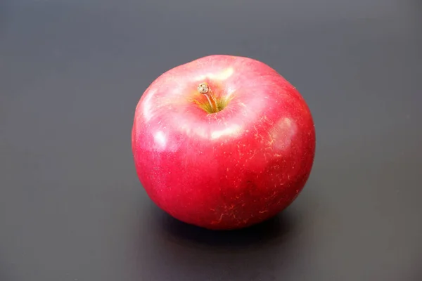 单鲜多汁的红苹果在深灰色背景与阴影特写视图 — 图库照片