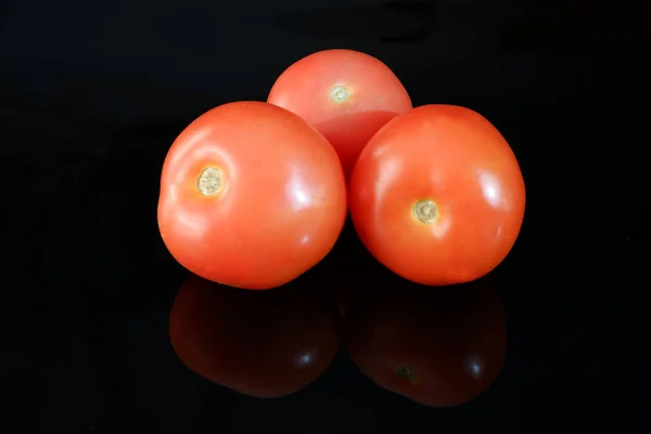 Tres Tomates Maduros Frescos Sobre Fondo Negro Brillante Con Reflejo — Foto de Stock