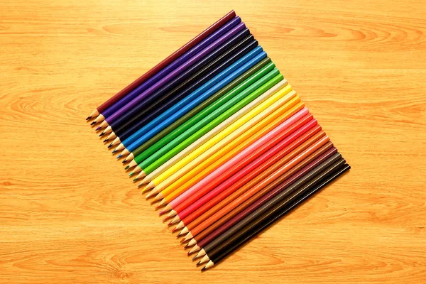Радуга из набора цветных карандашей на деревянном столе — стоковое фото