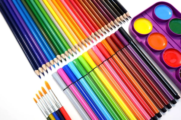 Sets of colored pencils, felt pen markers, watercolor paints and brushes on white background close up view — Stock Photo, Image