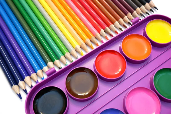 Sets of colored pencils and watercolor paints in plastic box on white background close up view — Stock Photo, Image