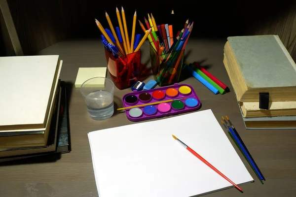 Concetto di rientro a scuola con quaderno vuoto, pitture ad acquerello, pennelli, cancelleria e libri scolastici — Foto Stock