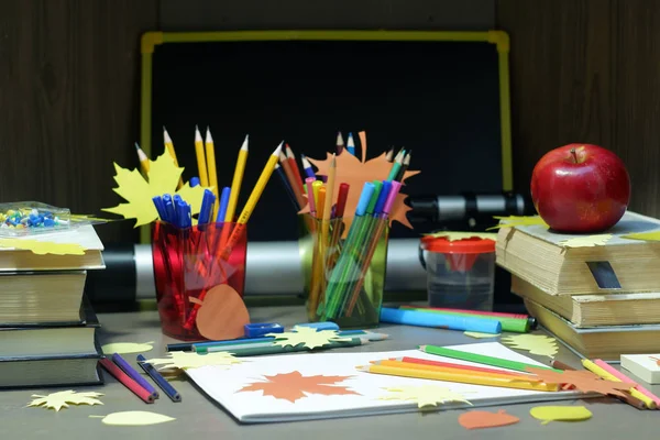 Вернуться к школьной концепции с пустыми эскизами, цветными карандашами, канцелярскими принадлежностями и учебниками на коричневом деревянном столе с яблочными и декоративными осенними листьями, избирательным фокусом — стоковое фото