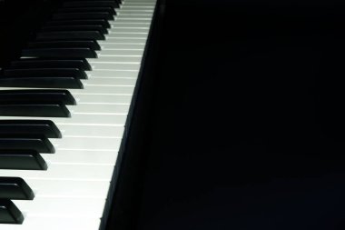 Siyah arka plandaki müzik klavyesi, metniniz için boş alan, seçici odakla görünümü kapatın