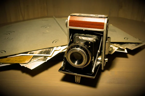 Retro old vintage outdated manual film camera circa 1940s and vintage photo album on wooden table. — Stock Photo, Image
