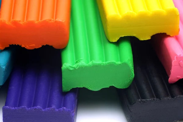 Orange, blue, green, yellow and black plastic clay sticks macro view, — 스톡 사진