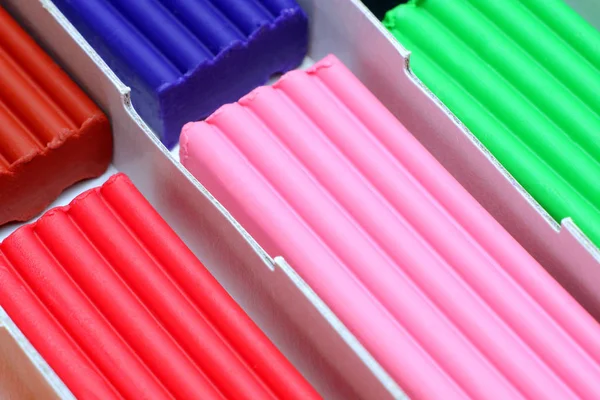 Bastoncini di plastica marrone, blu, arancione, rosa e verde in scatola di cartone . — Foto Stock