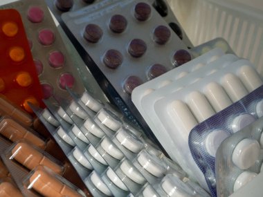 Çeşitli hastalıklar için ilaçlar bir rafta duruyor. Kabarcıklardaki ilaçlar. İş, endüstri, eczaneler, klinikler, hastaneler için tıbbi geçmiş.