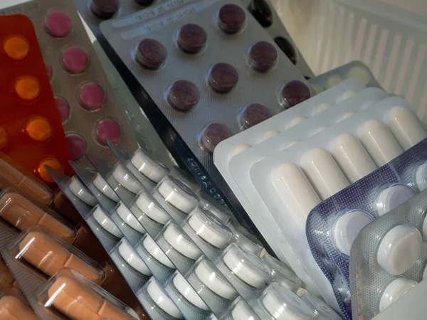 Çeşitli hastalıklar için ilaçlar bir rafta duruyor. Kabarcıklardaki ilaçlar. İş, endüstri, eczaneler, klinikler, hastaneler için tıbbi geçmiş.