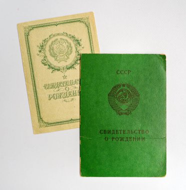 SSCB 'de bulunan bir çocuğun iki eski tarz doğum belgesi. Sertifikalar farklı zamanlarda kaydedilmiş ve tasarım olarak farklılık göstermiştir. Beyaz arkaplanda izole edilmiş kağıtlar.