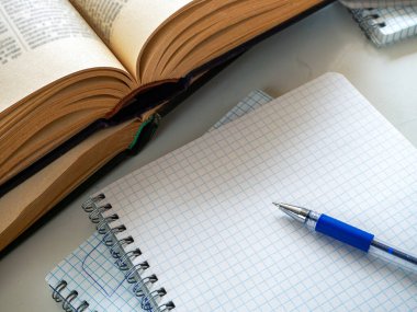İki açık kitap üst üste geliyor. Boş bir defter sayfasında bir kalem var. Boşluk. Kütüphaneler için arka plan, eğitim, bilimsel çalışma, üniversite, okul.