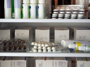 Kabarcıklar, tüpler, kutular ve ilaçlarla dolu diğer paketler buzdolabının raflarında düzgünce düzenleniyor. Çeşitli hastalıklar için ilaç içeren tıbbi geçmiş.