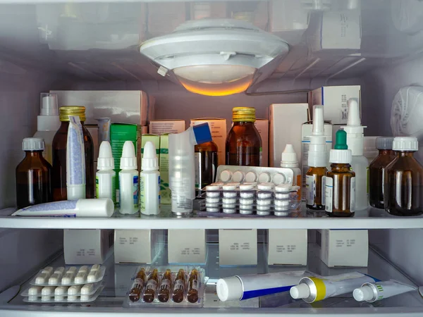 Çeşitli hastalıklar için çeşitli paketler halinde ilaçlar buzdolabının raflarına konur. Tabletler, spreyler, tentürler, merhemler ve diğer ilaçlarla tıbbi geçmişi.