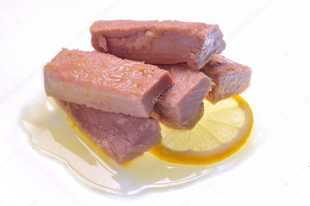 five fillets of rose tuna in oil on lemon slice and white background