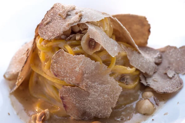 White truffle of Alba sliced on tagliolini-spaghetti, a prized Italian mushroom, close up