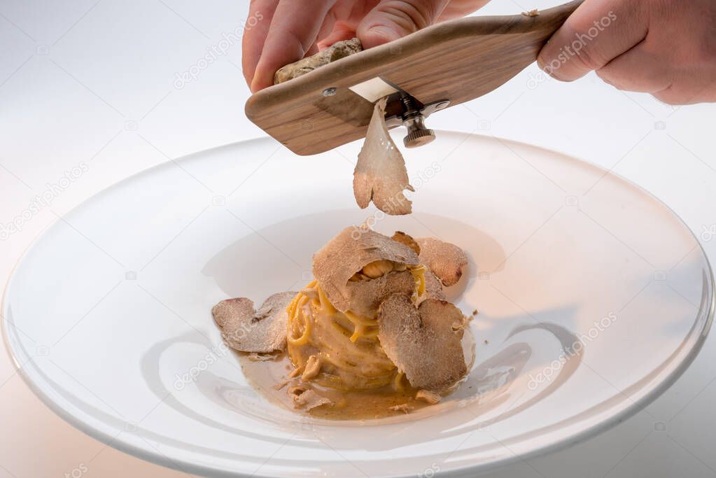 serve the white truffle from Alba in Italy with a slicer on a plate of tagliolini-spaghetti with egg