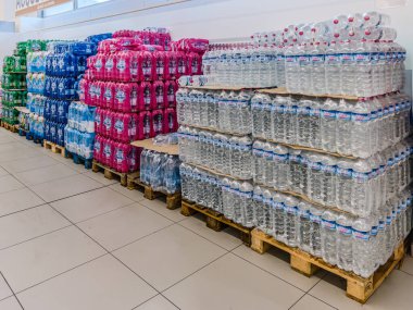İtalya - 18 Eylül 2025: Plastik şişelerdeki maden suyu indirimli pazarda satılmak üzere paketlendi ve paletlerin üzerine istiflendi