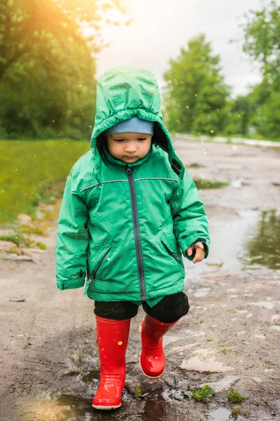 Een Kind Een Jongetje Een Groen Jasje Rode Laarzen Speelt — Stockfoto