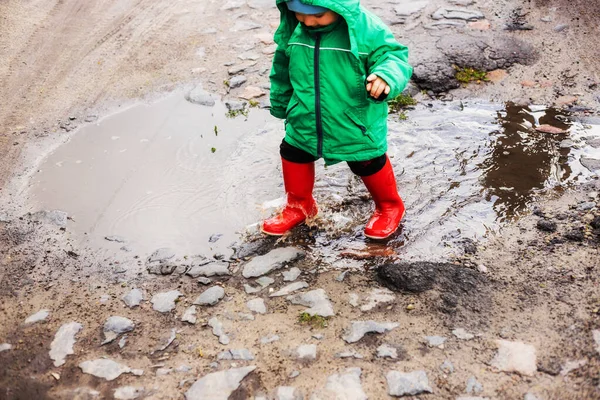 Ett Barn Liten Pojke Grön Jacka Och Röda Stövlar Leker — Stockfoto