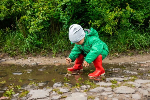 Criança Garotinho Casaco Verde Botas Vermelhas Joga Pântano Infância Despreocupada — Fotografia de Stock