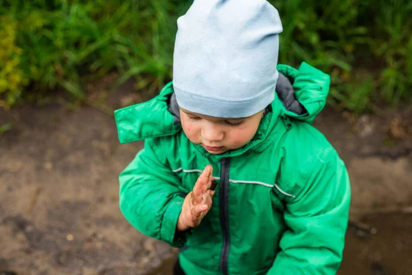 Ett Barn Liten Pojke Grön Jacka Och Röda Stövlar Leker — Stockfoto