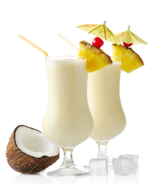 Coquetéis de pina colada com coco e cubos de gelo isolados em branco — Fotografia de Stock