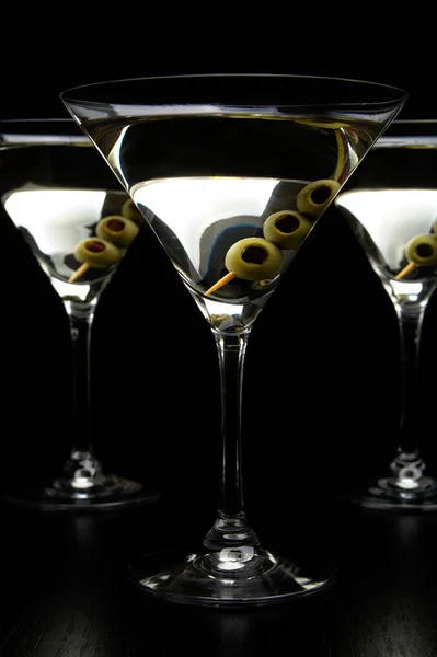Мартини с оливками, изолированными на черном — стоковое фото